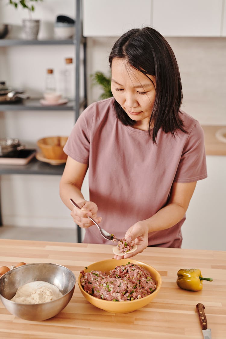 Photograph Of A Woman Making Dumplings