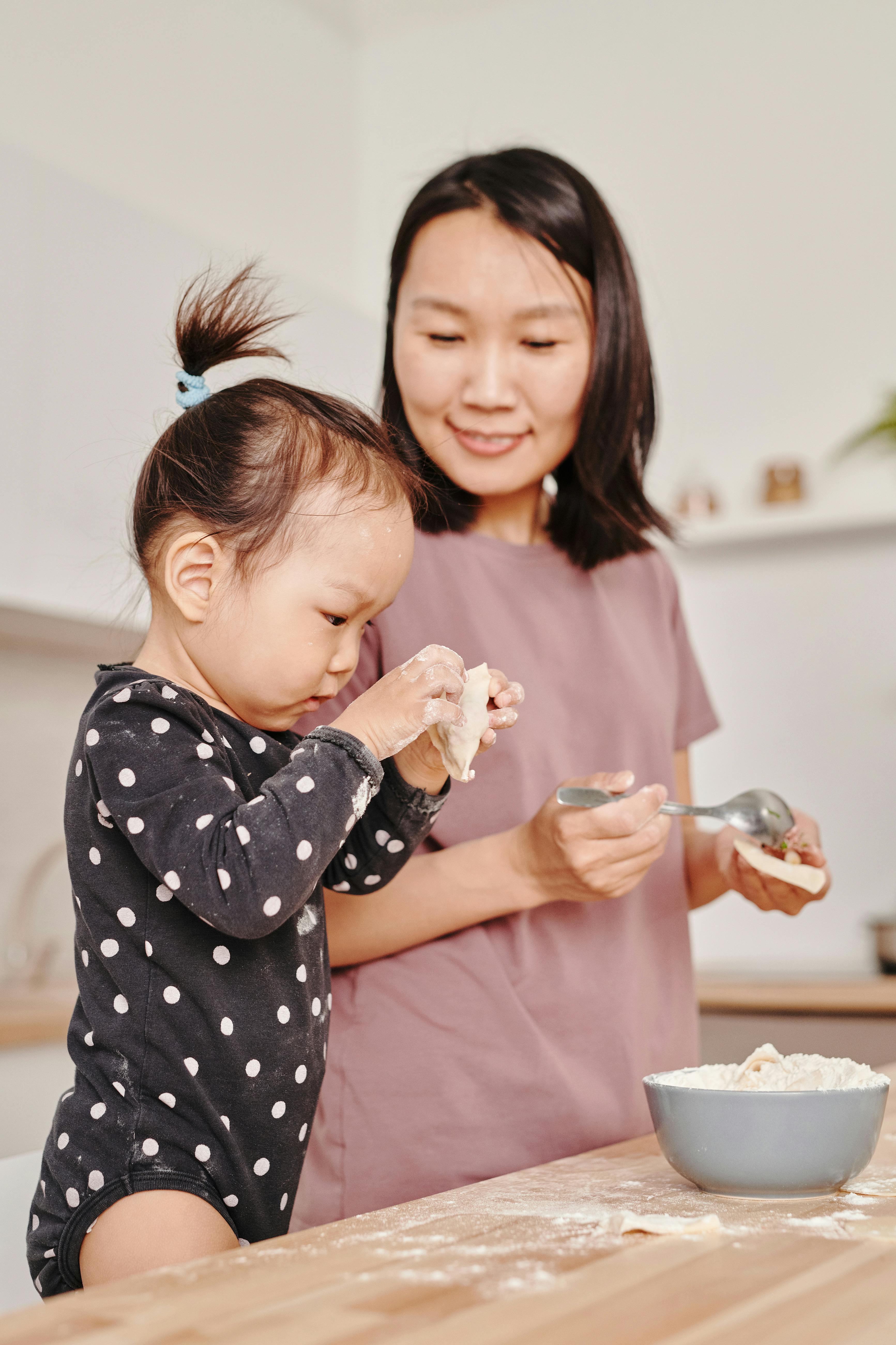 girl in black and white polka dot long sleeve shirt holding dumplings