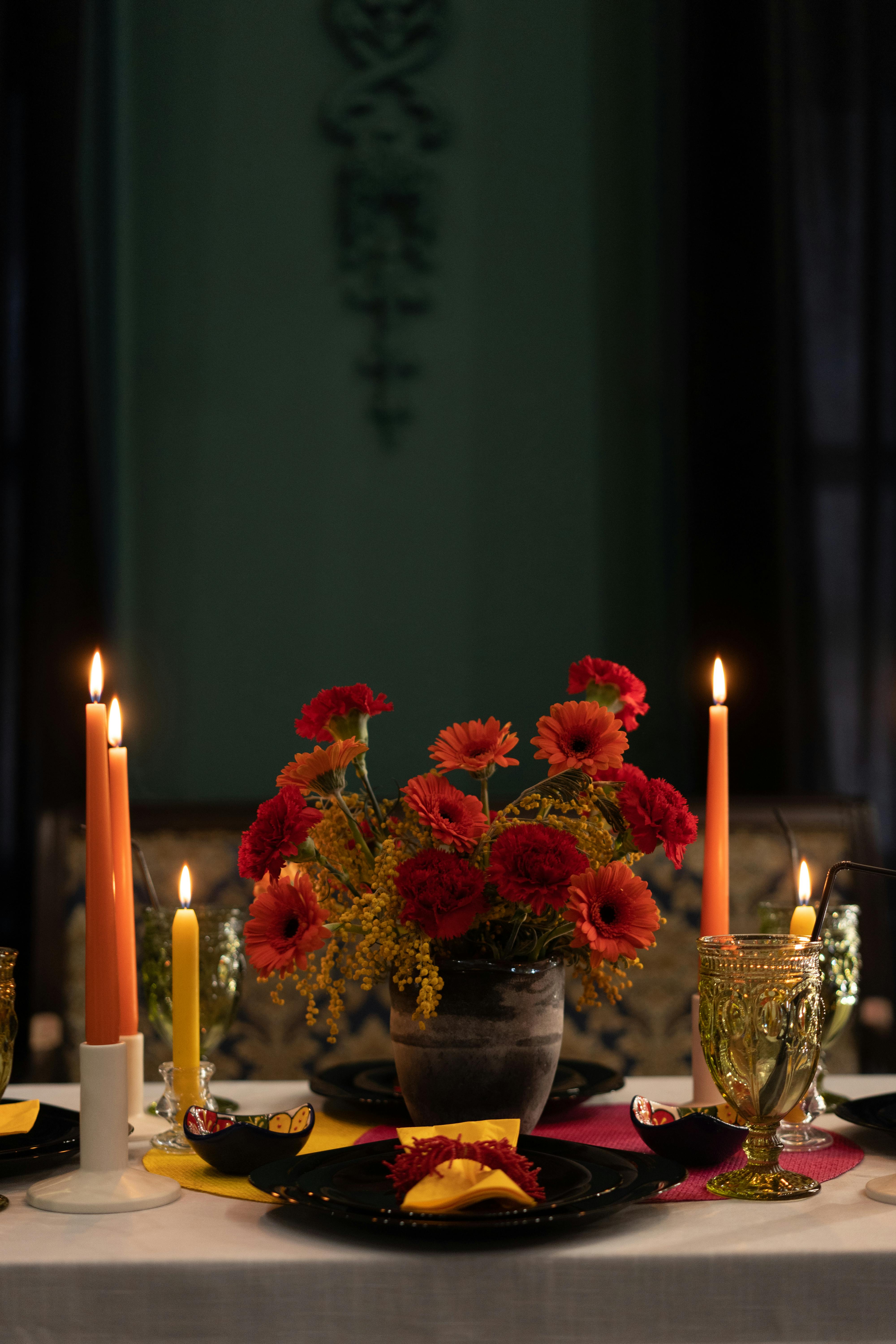 A beautifully set table with candles and vibrant floral centerpiece, perfect for celebrations.
