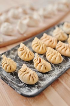 Freshly prepared homemade dumplings covered with flour, ready for cooking.
