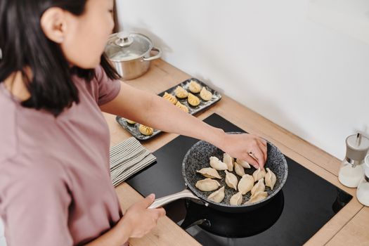 用锅盖作为盾牌，遮挡飞溅的油滴