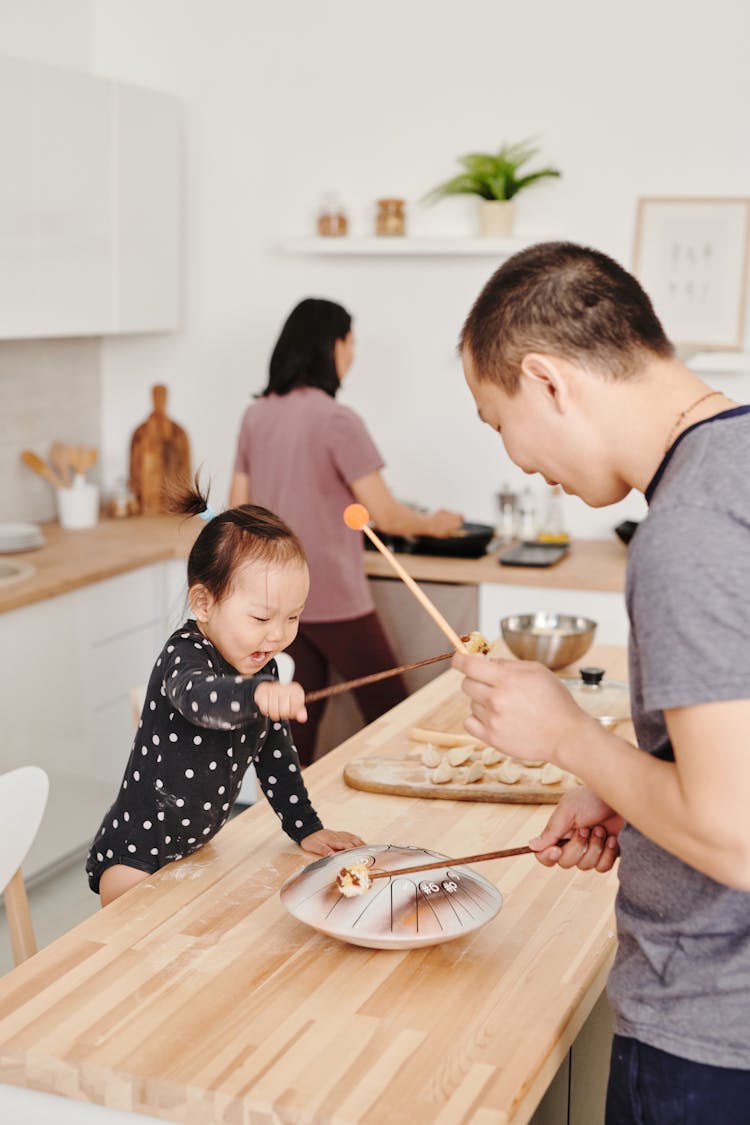 Father And Daughter Playing With Chopsticks