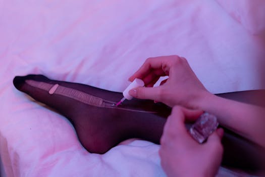 Close-up of a woman using nail polish to repair a run in stockings.