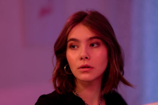 A captivating portrait of a woman with short hair and hoop earrings, surrounded by soft lighting.