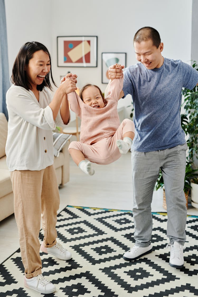 Mom And Dad Having Fun Playing Together With Their Daughter