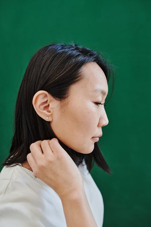 Gratis arkivbilde med asiatisk kvinne, grønn bakgrunn, hvit skjorte