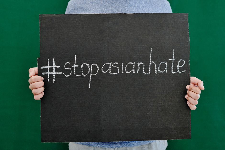 아시아인 혐오 반대 메시지인 #StopAsianHate가 적힌 플래카드를 들고 있는 손의 클로즈업.