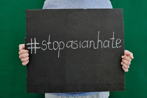 Free Close-up of hands holding a placard with #StopAsianHate message advocating against Asian hate. Stock Photo