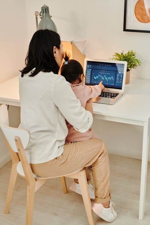 A Woman Using a Laptop with Her Child