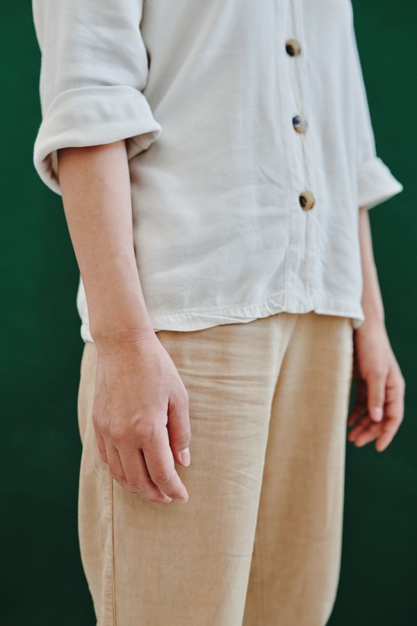 Person in a plain shirt and loose khaki trousers — photo by ShotPot on Pexels