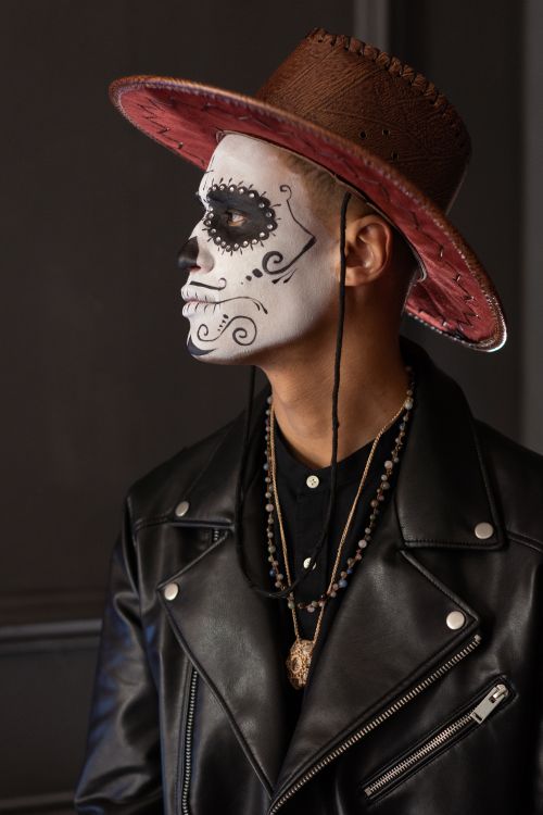 Free Man with skull makeup and hat celebrates Dia de los Muertos tradition. Stock Photo
