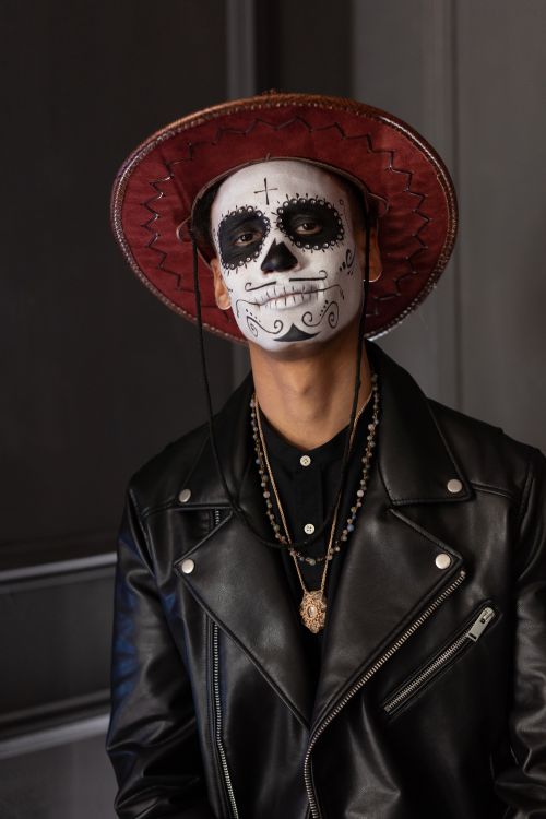 Free Portrait of a man wearing traditional Day of the Dead face paint and a stylish leather jacket. Stock Photo