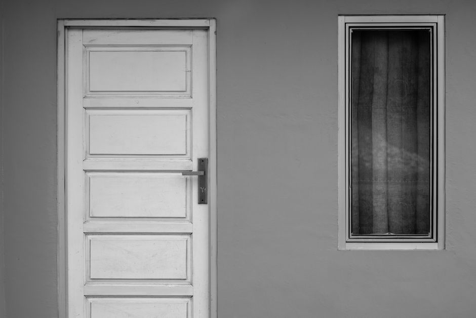 A minimalist black and white photo of a wooden door and glass window, perfect for modern design concepts.