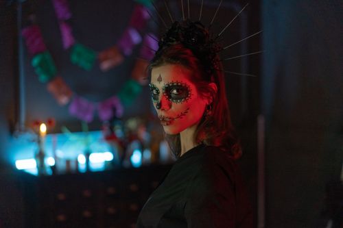 Free Woman with Dia de los Muertos makeup and headpiece in dark, atmospheric setting. Stock Photo