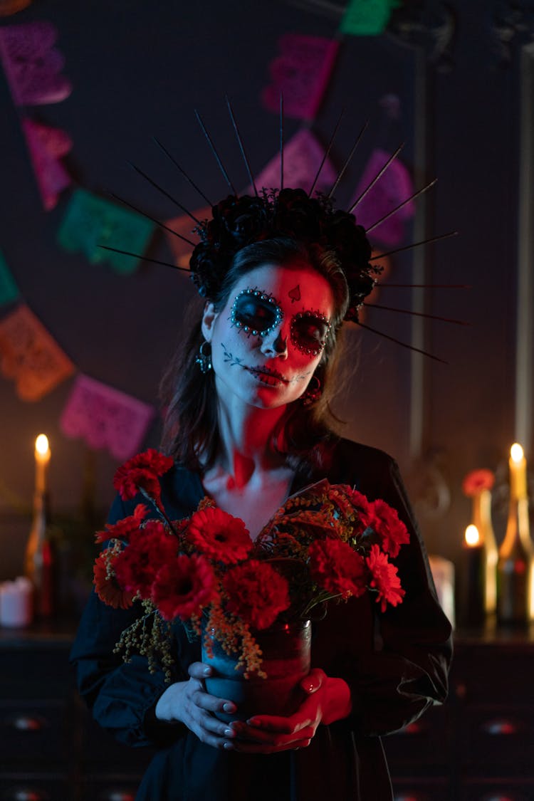 A Woman With Skeleton Face In Black Long Sleeves Holding Flowers