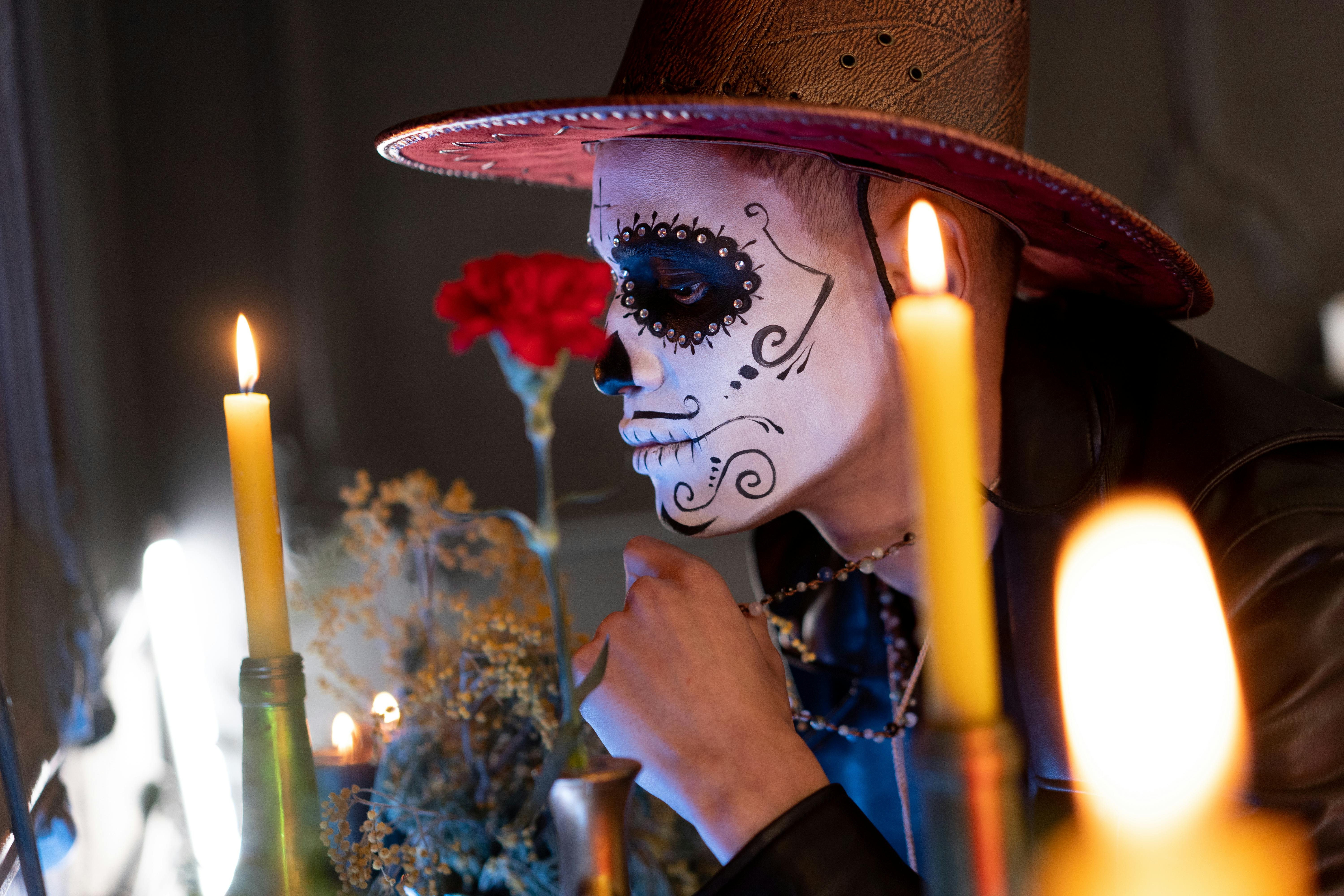 a man with face paint and lighted candles