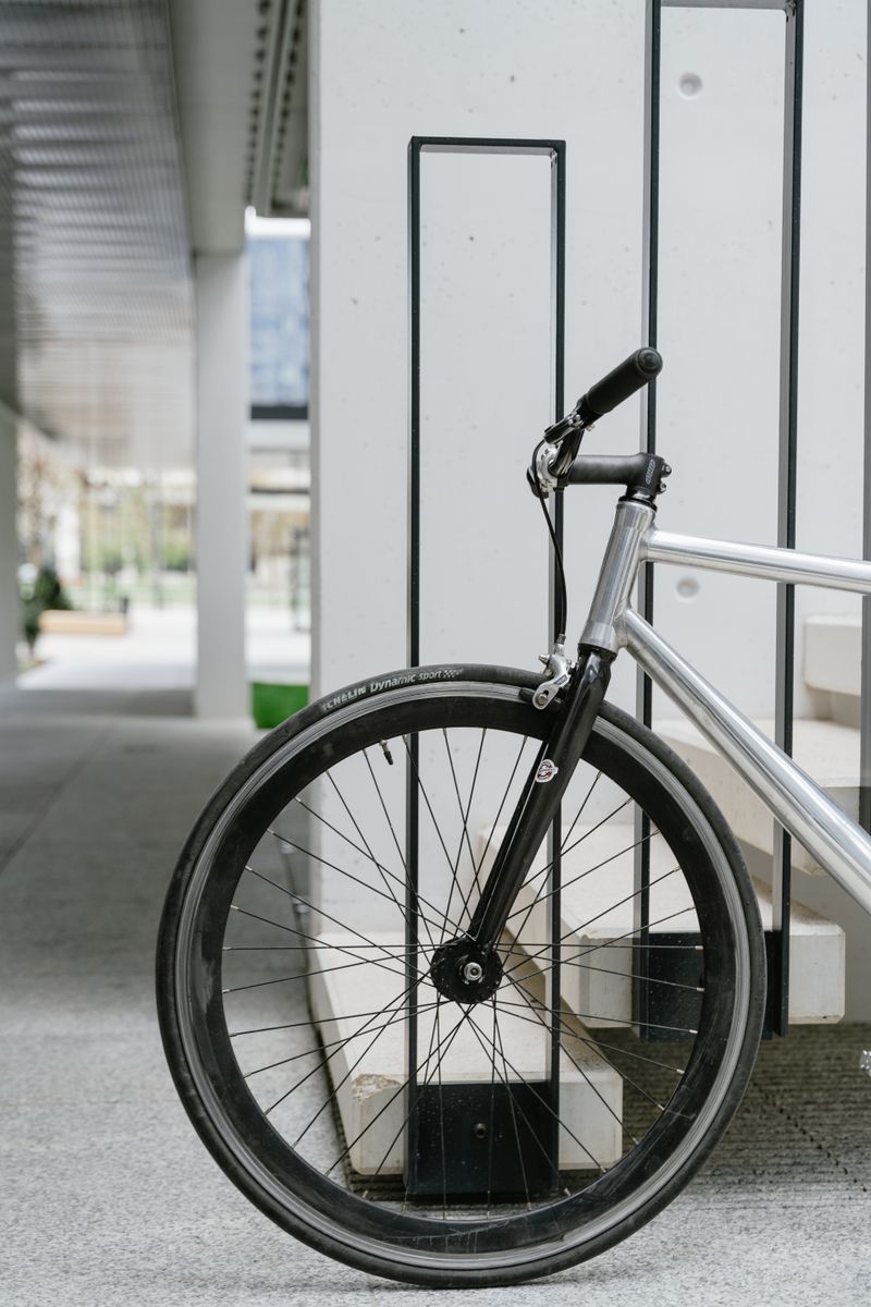 A sleek bicycle wheel against a modern architectural backdrop in a city