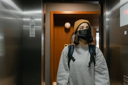 Woman in Gray Sweater in an Elevator