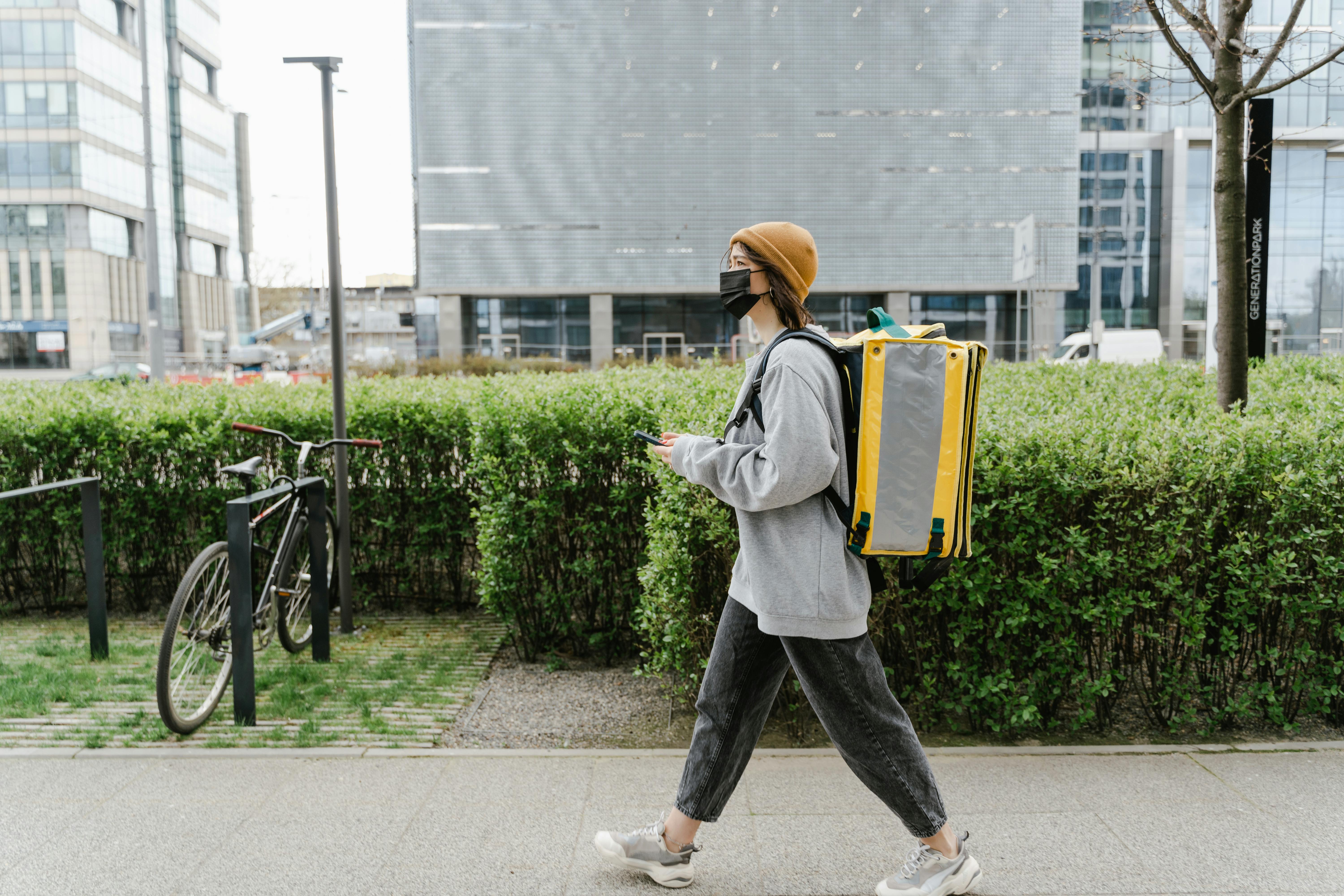 woman carrying a yellow bag walking