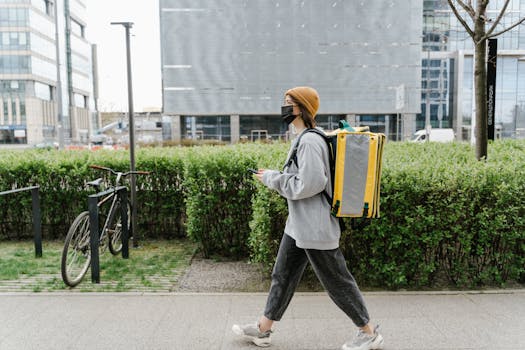 A delivery person walking through Warsaw with a yellow thermal bag, providing urban food delivery services.