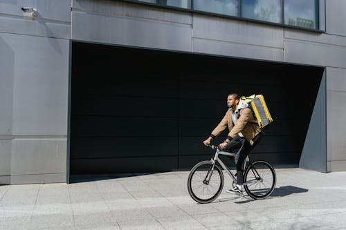 Man in Brown Jacket Riding a Bicycle