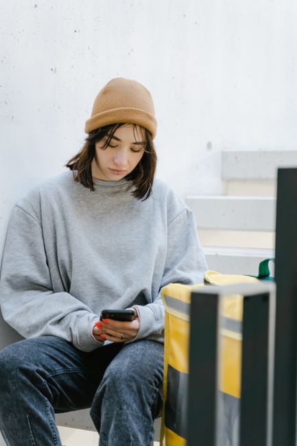 A person checking a smartphone for updates from official emergency alert systems.