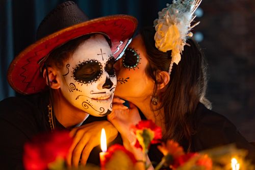 Free A romantic moment during a Day of the Dead celebration with couples in traditional makeup. Stock Photo