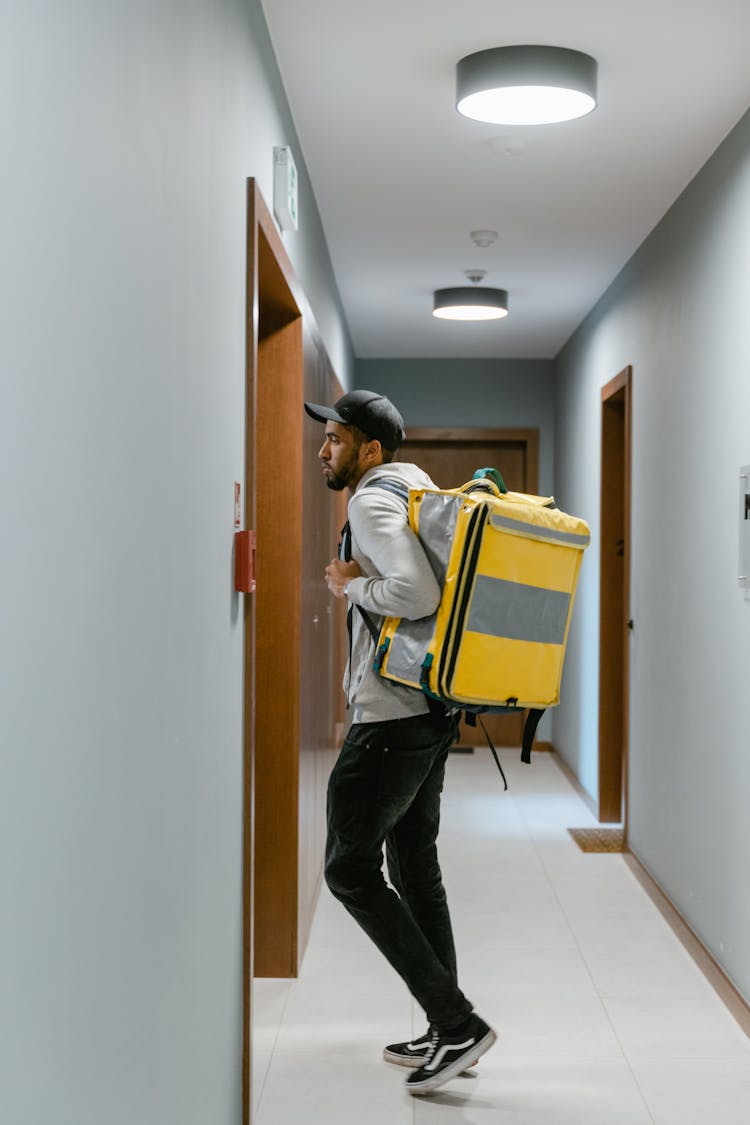 Man In A Sweater And Black Pants Standing At The Door