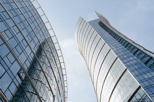 Low-angle view of modern glass skyscrapers in Warsaw, Poland against a clear blue sky.