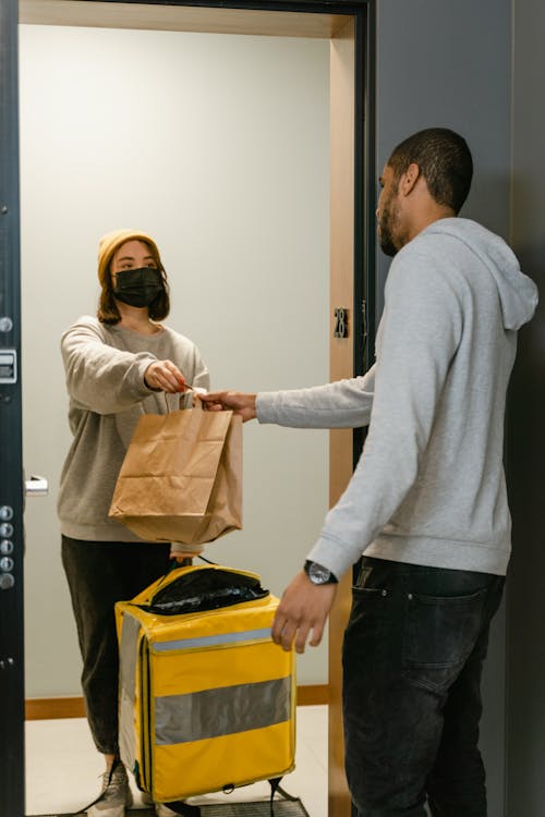 Man in Gray Sweater Holding a Paper Bag