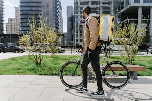 Cyclist carrying thermal bag in urban setting, ideal for delivery service concepts.