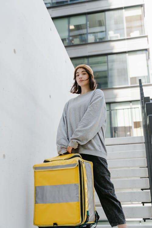 Woman in Gray Sweater Standing on a Staircase