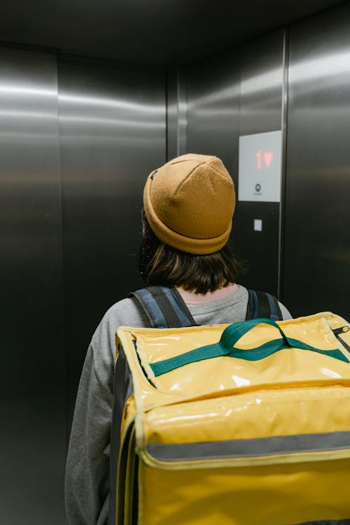 Woman in a Beanie Inside an Elevator