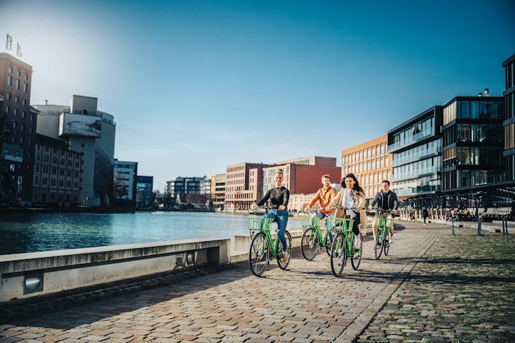 People Cycling Near Water In Town