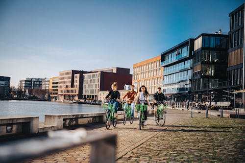 Free People Riding Bicycles on Road Near River Stock Photo