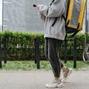 Person Carrying a Bag Walking on the Sidewalk