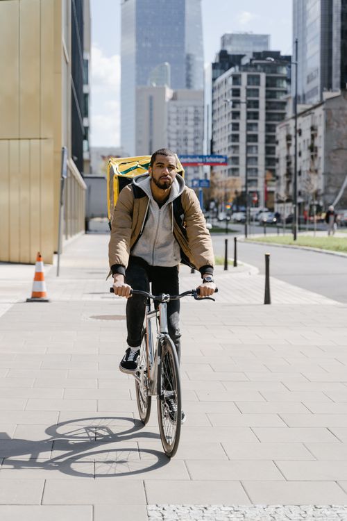 Free Courier on a bicycle delivering food in downtown Warsaw. Stock Photo