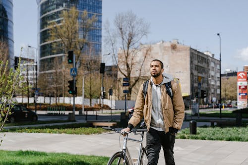Man in Brown Jacket Standing on a Sidewalk