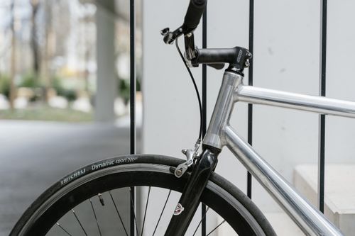 Free Detailed view of a modern bicycle with a focus on the black tire and metal frame, perfect for urban transportation concepts. Stock Photo