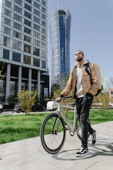 A courier with a backpack walks a bicycle in modern Warsaw, delivering parcels.
