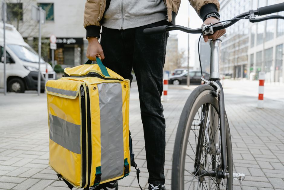 A delivery driver carrying a thermal bag with Indian food A delivery driver carrying a thermal bag with Indian food