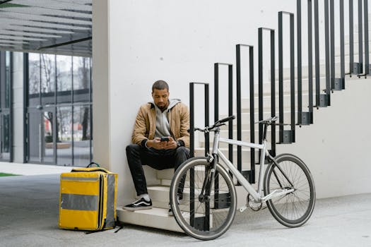 Cyclist with a delivery bag taking a break in an urban setting. Modern city life captured.