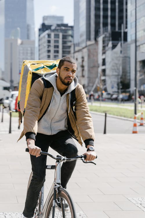 Man in Brown Jacket Riding a Bicycle