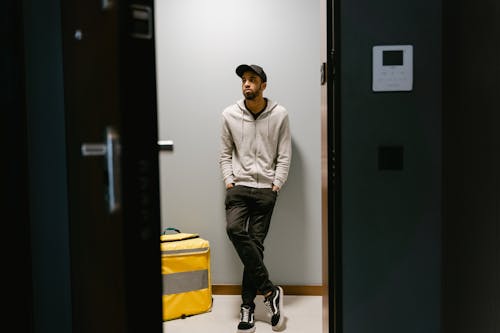 Photo of a Man in a Gray Hoodie Waiting