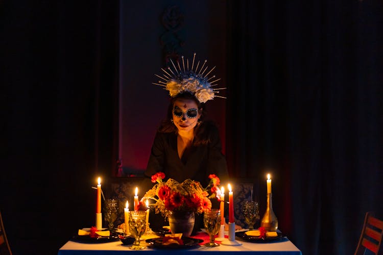 Photograph Of A Woman With Face Paint Near Lit Candles