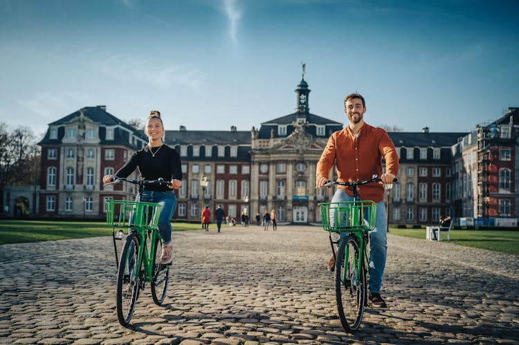 Woman And Man On Bicycles Near Residence