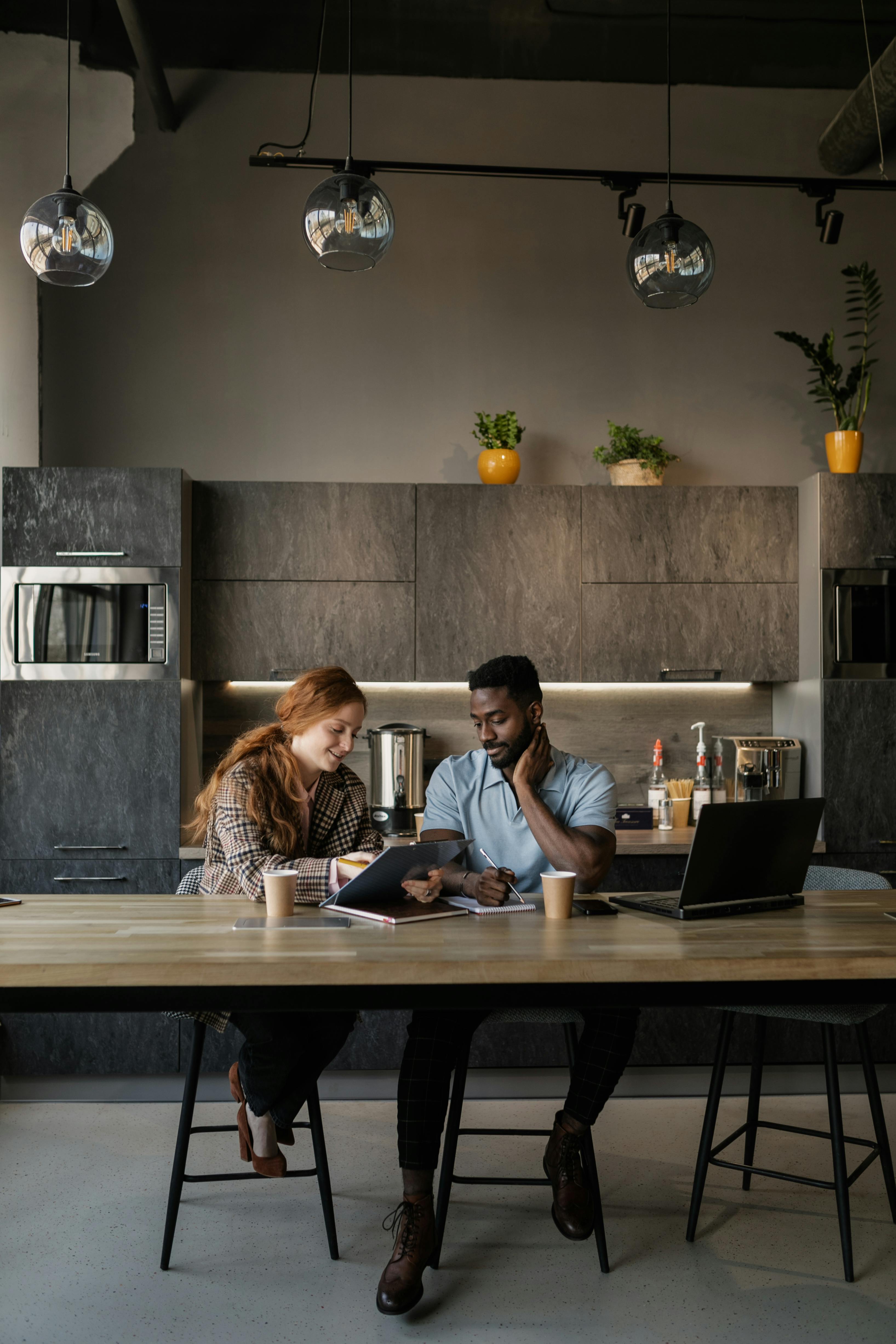 a man and woman sitting near the wooden table while having conversation