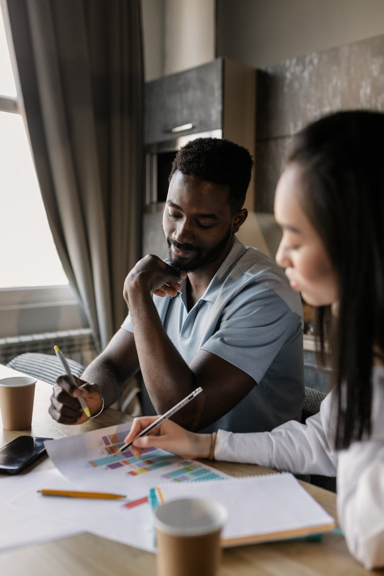 A Man And A Woman Discussing Graphs