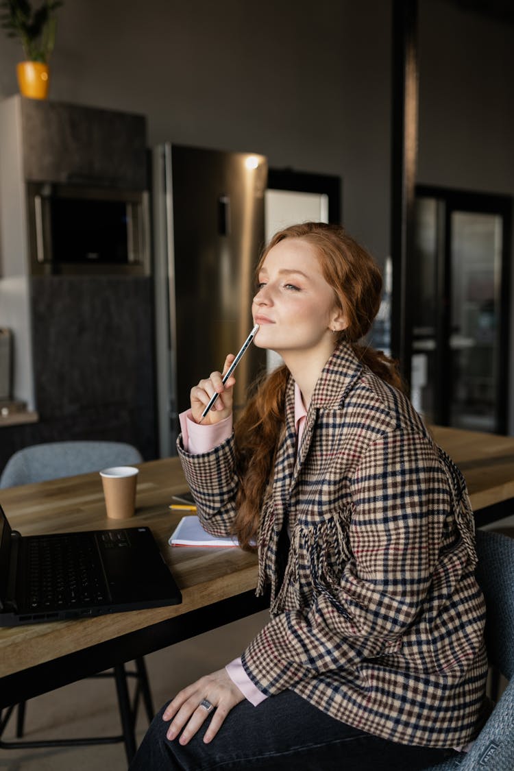 Redhead Woman In Checkered Coat Sitting On Chair