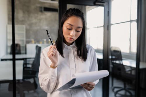 Free Photo of a Woman Holding a Pen and a Clipboard Stock Photo